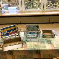 Vier Karton-Bühnen mit Vorhangstangen.