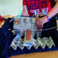 Spieler mit Karton-BauchLadenTheater mit Bühnenbild.